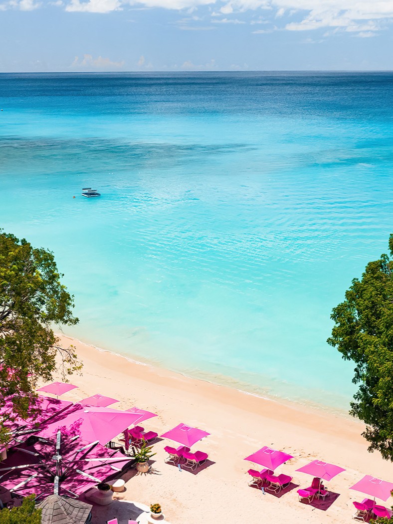 Sandy Lane's white-sand beach with pink umbrellas on the Platinum Coast