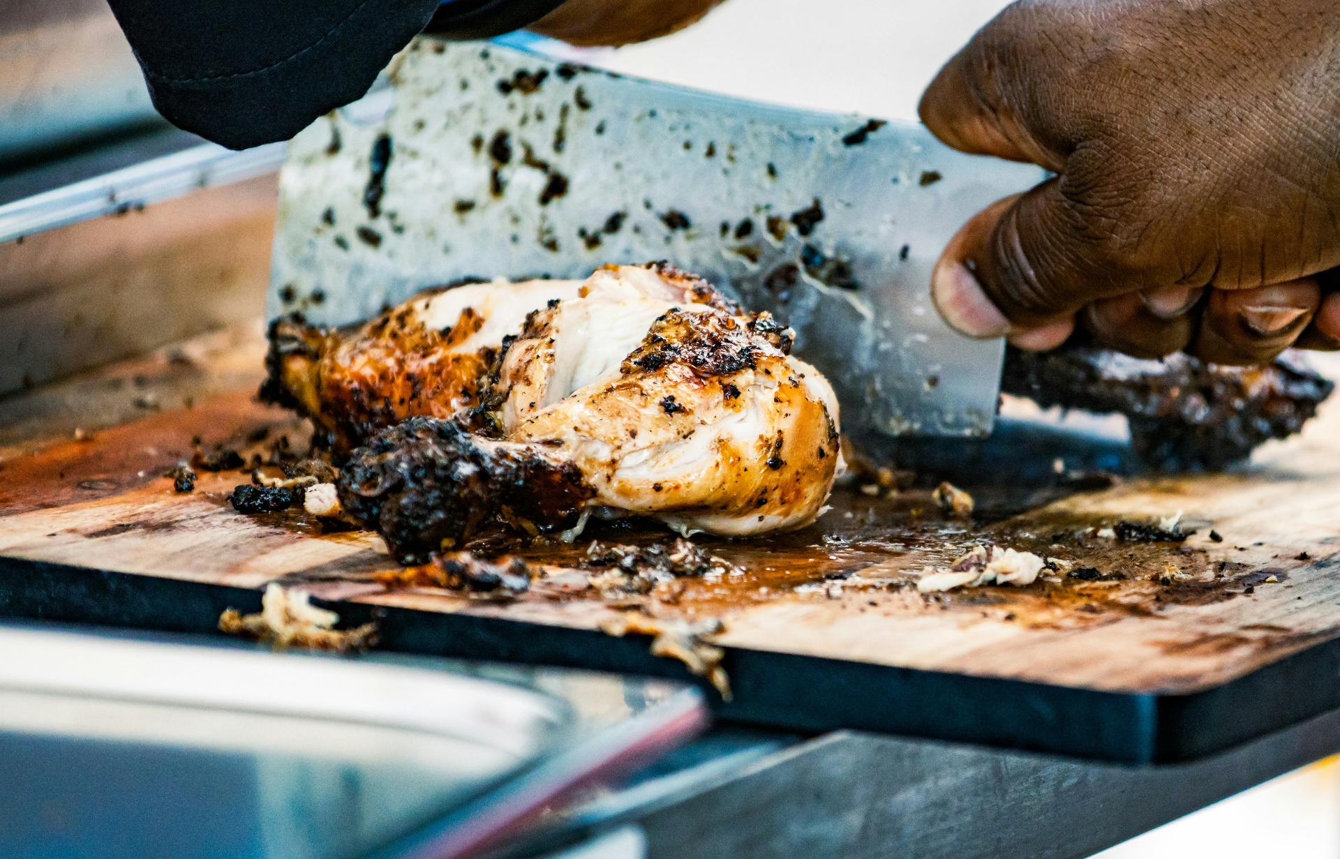 Jerk chicken being chopped on a board — Lickrish Food Tours